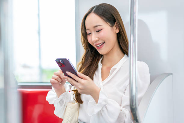istock Asian woman sitting and using phone while commuting on a metro skytrain 2157113585