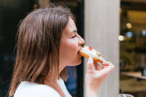 istock Young lady savors a delicious cheese and olive toast 2157119397
