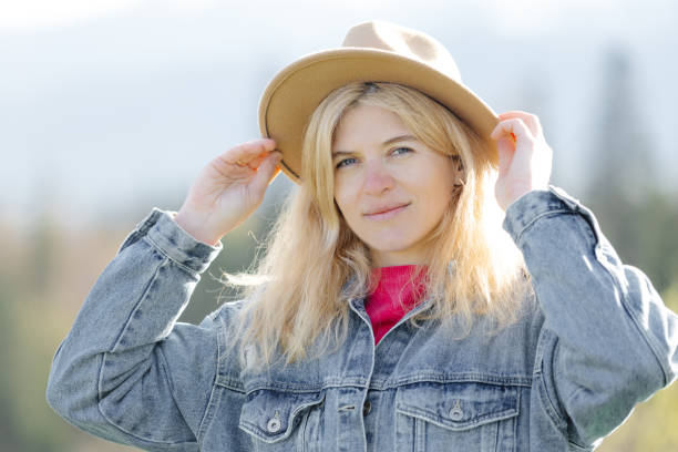 istock Woman adjusting hat outdoors 2157119876