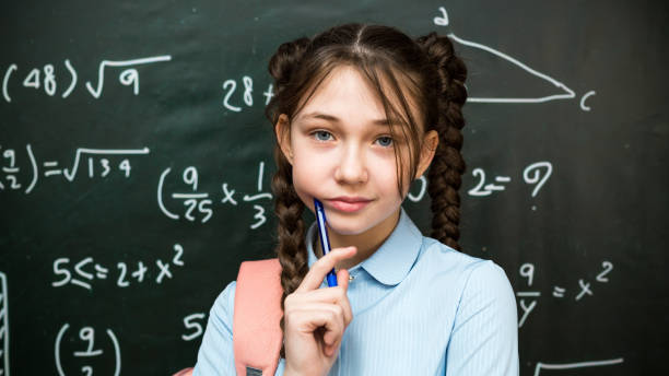 istock Girl student chatting with a pen, bringing it to her face 2157120587