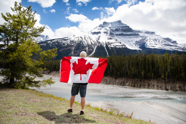 Hiker holds Canadian flag in mountains