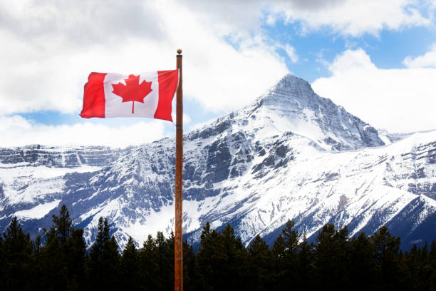 istock Canadian flag blows in the wind below mountains 2157124367