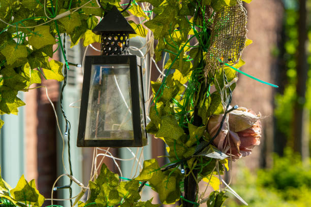 old lamp is hanging from a vine and has a flower on it