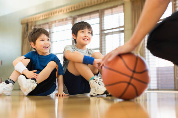 istock Boys practising with their coach on the basketball court. 2157128432