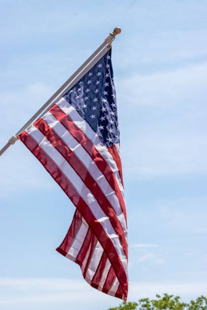 istock American flag waving against a clear blue sky on a sunny day. 2157129944