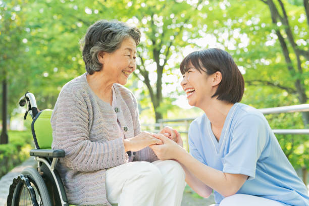 senior woman in wheelchair and female health care worker. - 看護師 笑顔 ストックフォトと画像