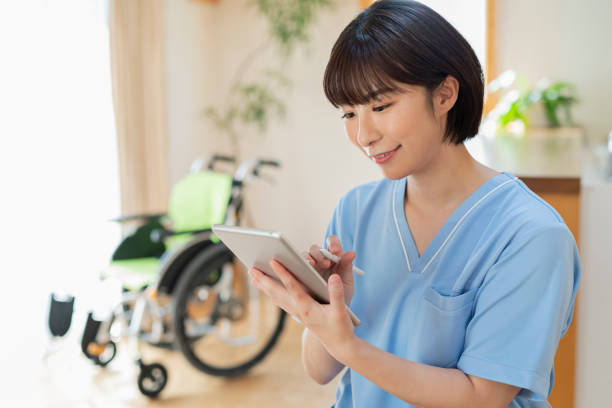 istock Female health care worker writing a logbook on a tablet. 2157134622