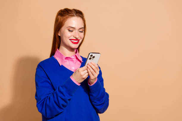 istock Photo of charming attractive lady dressed blue pullover chatting apple iphone samsing device empty space isolated beige color background 2157134821