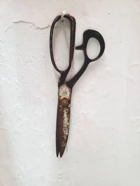 istock Rusty scissor hanging on the white wall 2157135405
