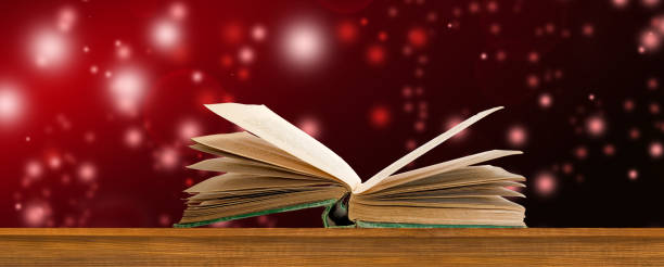 An Open Book Against A Crimson Sky With Shimmering Lights