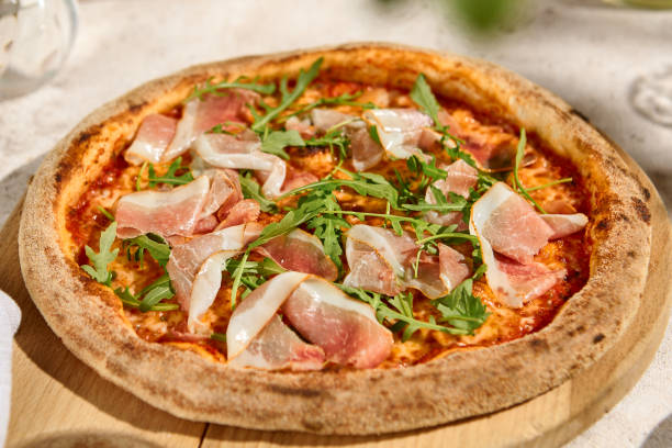 istock Delicious Parma Ham and Arugula Pizza in Summer Sunlight with Natural Shadows 2157135543