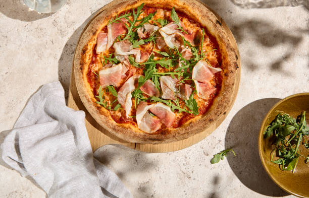 istock Delicious Parma Ham and Arugula Pizza in Summer Sunlight with Shadows 2157135545