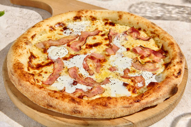 istock Delicious Bacon and Cream Sauce Pizza in Sunlit Summer Setting 2157135550
