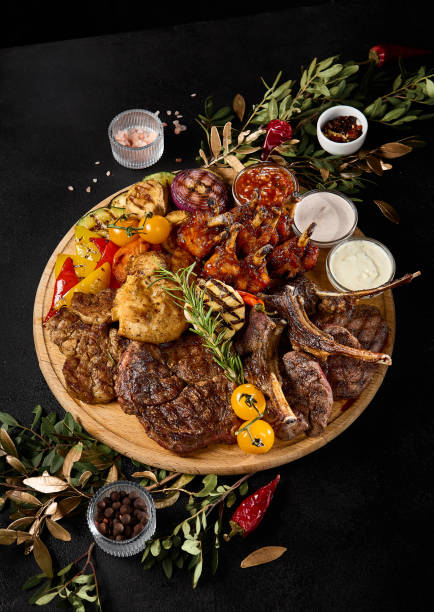 istock Assorted Grilled Meats and Vegetables Feast on Wooden Platter 2157135694