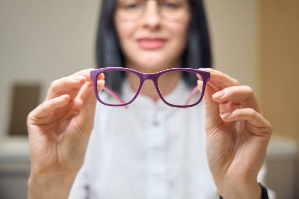 istock Woman holds glasses with lilac frames in her hands 2157137827
