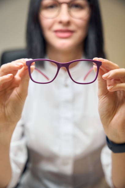 istock Brunette holds glasses with lilac frames in her hands 2157137839