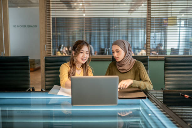 istock 2 Asian businesswomen discussing strategy and ideas at office 2157140131