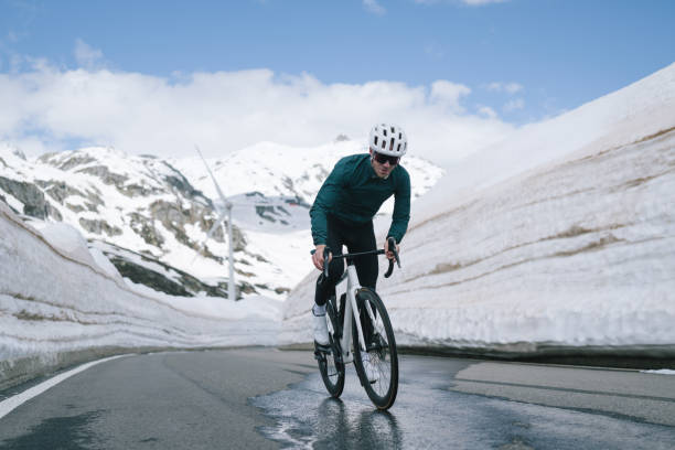 Road biker rides up high mountain pass