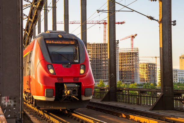 istock Red electric passenger train over a bridge at sunset 2157142634