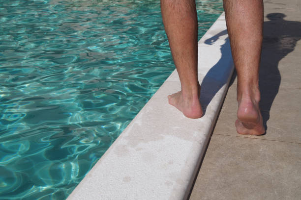 istock A Man Walks Along The Edge Of The Pool 2157145695
