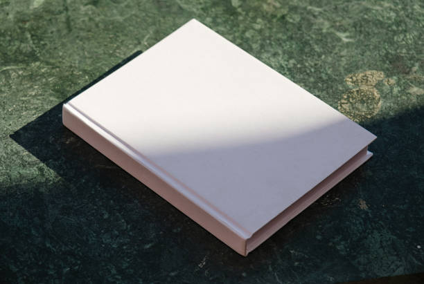 istock blank book mockup on green marble stone coffee table , shadow overlay 2157151082