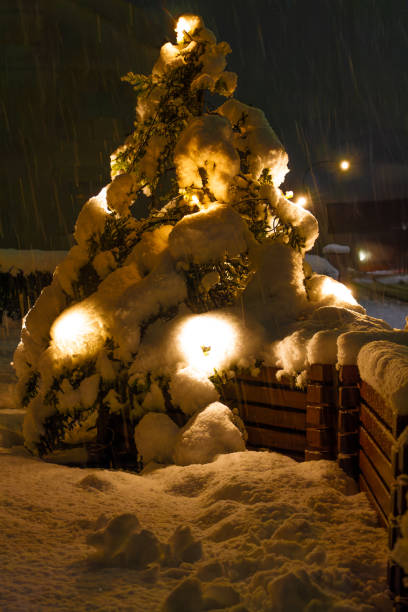 Christmas tree decorated with garland and glowing ornaments