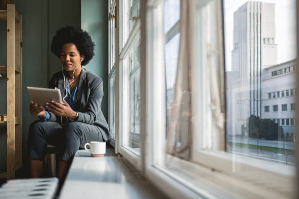 istock Woman with Tablet on Window Sill 2157152245