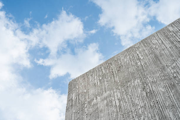 Empty new Grey cement free space background Wall exterior detail abstract stone background Studio texture and blue sky background texture with white clouds