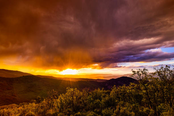 Eagle Colorado Summer Sunset Time Lapse - Scenic high sage meadow with storm clouds moving through mountains at sunset lighting up with intense warm colors and dramatic sky. 4K time lapse, high resolution. Eagle, Colorado USA.