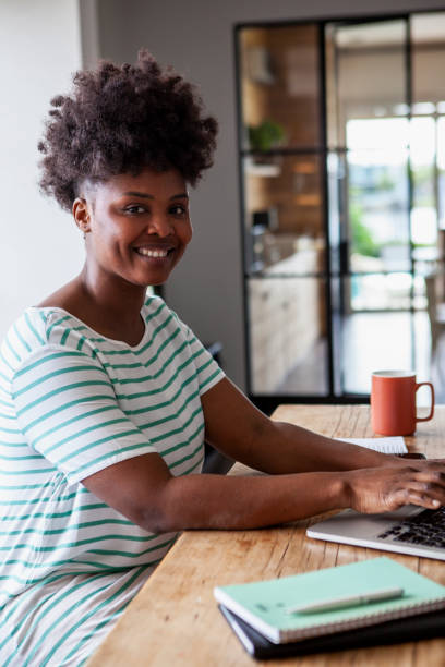 istock Young African American entrepreneur typing on laptop computer while working from home 2157154035