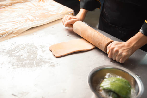 istock A chef in a kitchen skillfully rolls dough to bake pastry, showcasing culinary expertise 2157154309