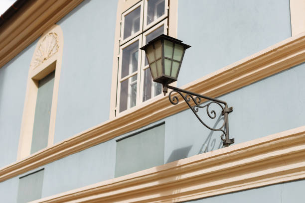 Architectural details featuring a decorative lantern on a blue building with cream accents and antique windows.