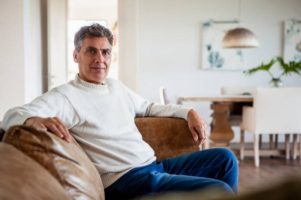 istock Middle-aged man sitting placidly on sofa while enjoying his day off 2157154511