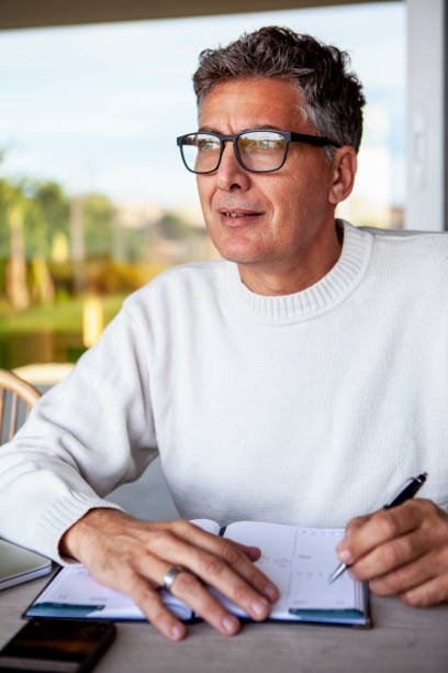 istock Mature man writing on calendar while working remotely from home 2157154523