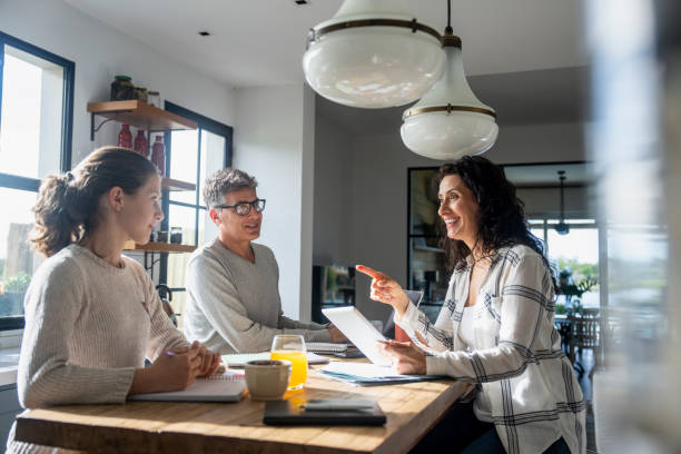 istock Mother and daughter discussing homework while father is busy doing office work from home 2157154590