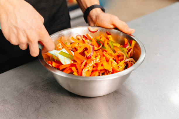 istock Fresh vegetable salad being mixed in a stainless steel bowl on a kitchen counter 2157154972