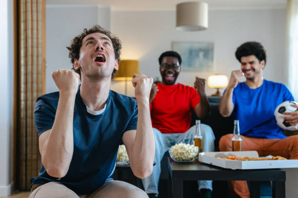 istock Happy friends cheering and celebrating goal 2157157488
