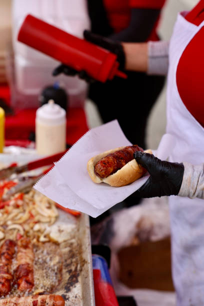istock Street vendor dressing a hotdog 2157160500