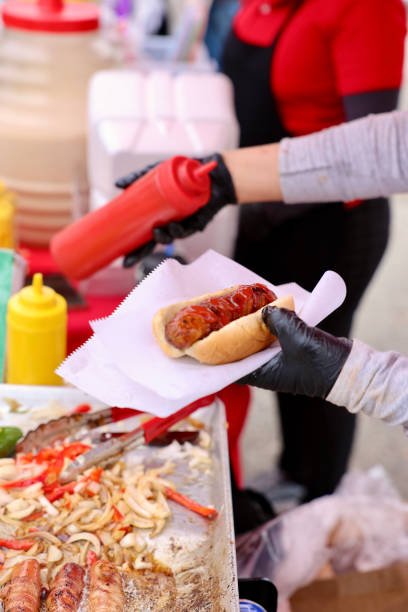 istock Street vendor dressing a hotdog 2157160505