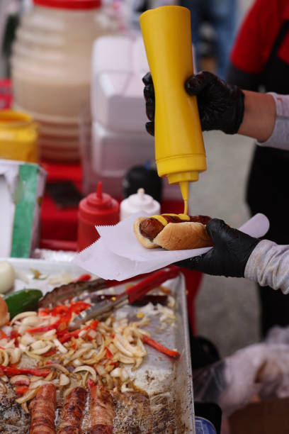 istock Street vendor dressing a hotdog 2157160516