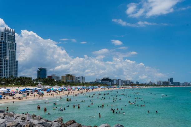 istock Crowded South beach filled with swimmers on a sunny day with blue sky and a skyline 2157160532
