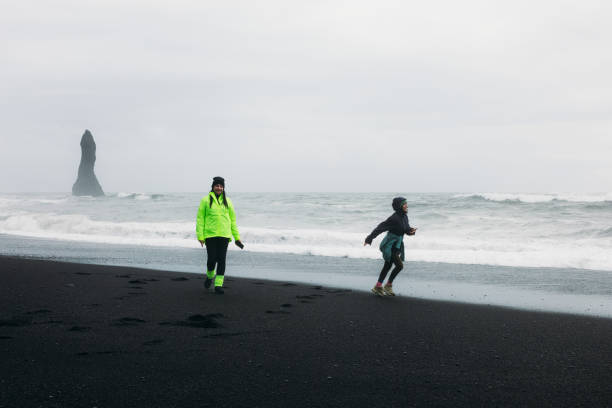 istock Two Happy Tourists Feeling Freedom Together at Idyllic Black Sand Beach 2157165767