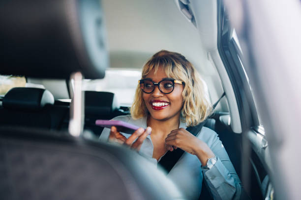 istock Smiling Woman Using Smartphone Voice Assistant in Car 2157165902
