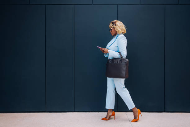 Professional Woman Walking Outdoors Using Smartphone