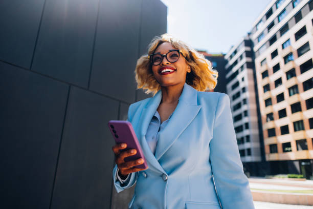 Confident Businesswoman Walking Outdoors with Smartphone