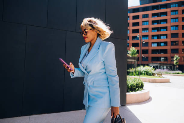 istock Businesswoman Walking Outside While Using Smartphone 2157165953
