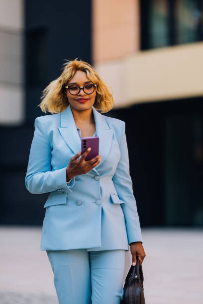 istock Confident Businesswoman Using Smartphone in Stylish Blue Suit 2157165955