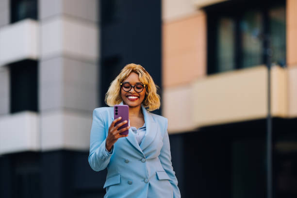 istock Happy Professional Woman Using Smartphone Outside Modern Office Building 2157165965