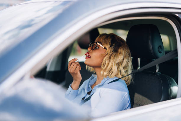 istock Woman Applying Lipstick While Sitting Inside Car 2157165983