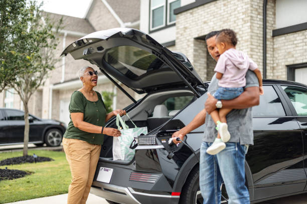 istock Grandparents and Young Parent Charging EV and Unloading Groceries 2157166060